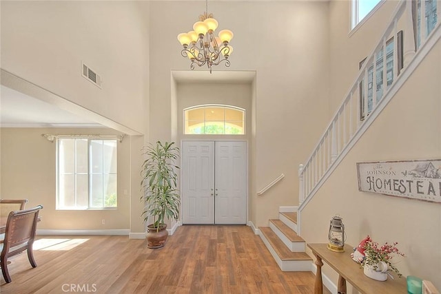 14182 Whitebark Ave, Chino, CA 91710 - entrance foyer featuring a towering ceiling, stairway, wood finished floors, and a chandelier