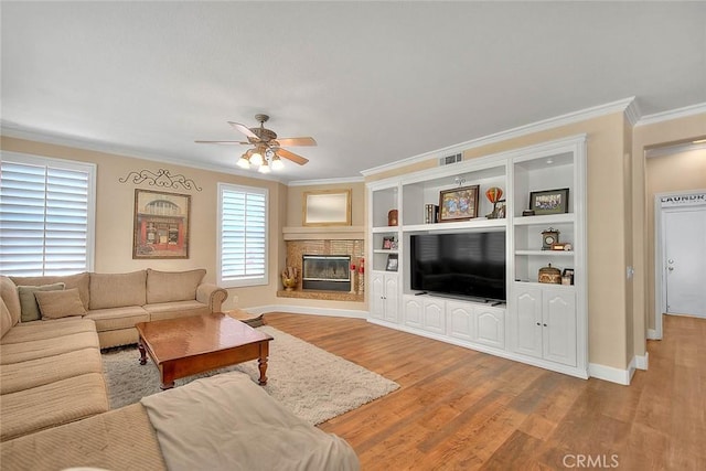 14182 Whitebark Ave, Chino, CA 91710 - living room featuring crown molding, ceiling fan, wood finished floors, and a glass covered fireplace