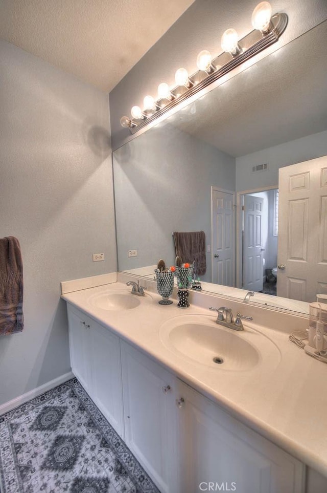 14182 Whitebark Ave, Chino, CA 91710 - full bathroom featuring double vanity and a textured ceiling