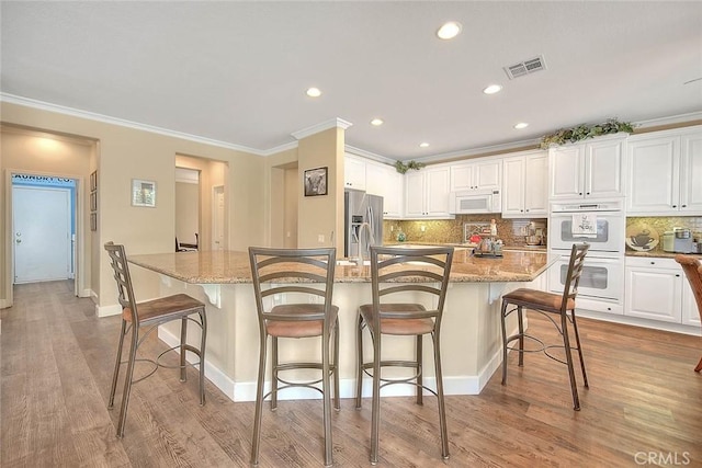 14182 Whitebark Ave, Chino, CA 91710 - kitchen with white appliances, white cabinetry, tasteful backsplash, recessed lighting, and crown molding