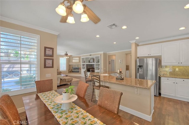 14182 Whitebark Ave, Chino, CA 91710 - kitchen with stainless steel fridge, ceiling fan, crown molding, wood finished floors, and white cabinetry
