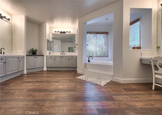 14182 Whitebark Ave, Chino, CA 91710 - bathroom with healthy amount of natural light, a bath, two vanities, and wood finished floors