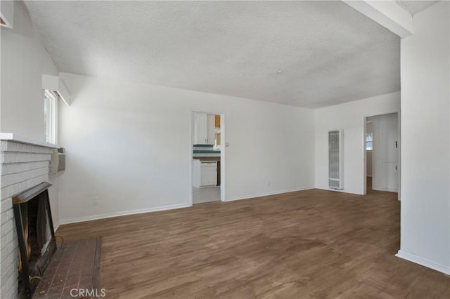 2210 W 7th St, Santa Ana, CA 92703 - unfurnished living room with a heating unit, a textured ceiling, a fireplace, and wood finished floors