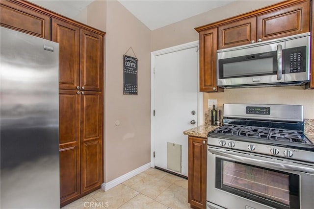 7471 Windrose Dr, Highland, CA 92346 - kitchen featuring appliances with stainless steel finishes, light stone countertops, and light tile patterned flooring