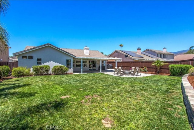 7471 Windrose Dr, Highland, CA 92346 - rear view of house featuring a patio area, stucco siding, a tile roof, and a chimney