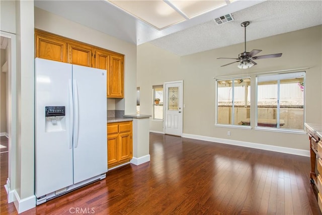 769 Amber Sky St, Banning, CA 92220 - kitchen with white fridge with ice dispenser, brown cabinetry, a ceiling fan, dark wood-style floors, and a textured ceiling