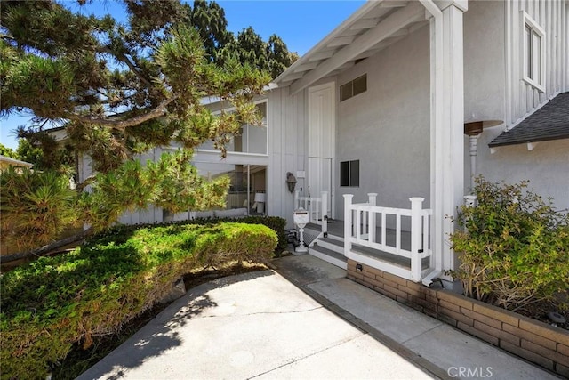 18312 Hartlund Ln, Huntington Beach, CA 92646 - doorway to property with board and batten siding and stucco siding