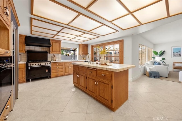 18312 Hartlund Ln, Huntington Beach, CA 92646 - kitchen featuring tasteful backsplash, light tile patterned floors, custom exhaust hood, and open floor plan
