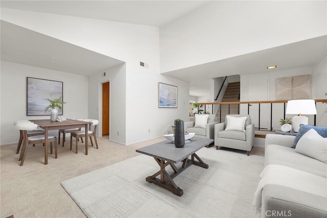 18312 Hartlund Ln, Huntington Beach, CA 92646 - living area with stairs, a high ceiling, and light carpet