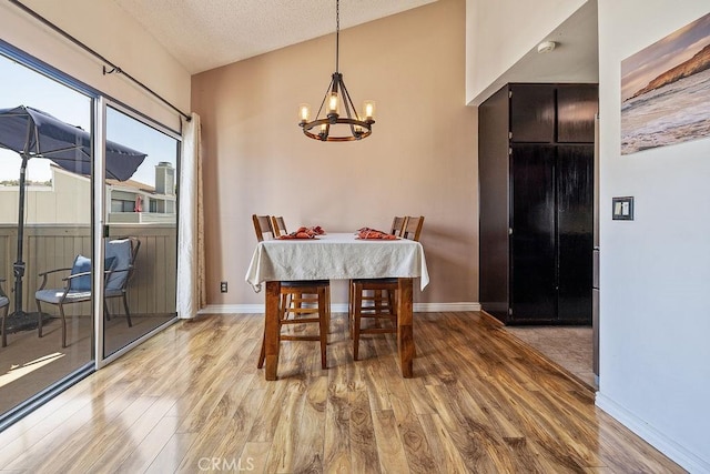 27066 Hidaway Ave Unit 6, Canyon Country, CA 91351 - dining space with a chandelier, wood finished floors, and a textured ceiling