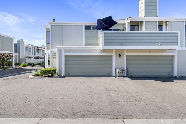 27066 Hidaway Ave Unit 6, Canyon Country, CA 91351 - view of front facade featuring a garage, a chimney, driveway, and a balcony
