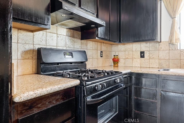 27066 Hidaway Ave Unit 6, Canyon Country, CA 91351 - kitchen featuring black gas stove, under cabinet range hood, decorative backsplash, and light countertops