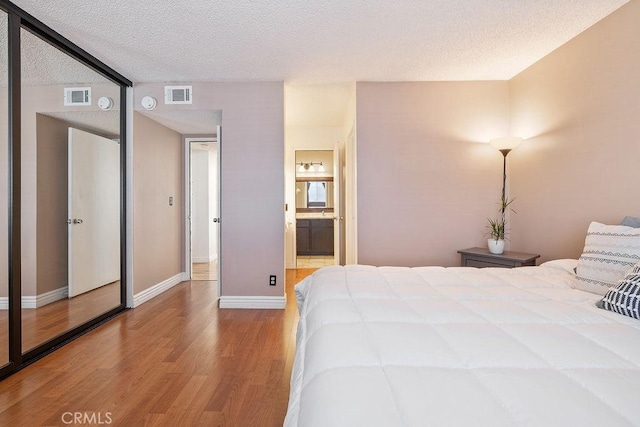 27066 Hidaway Ave Unit 6, Canyon Country, CA 91351 - bedroom with wood finished floors, a textured ceiling, and ensuite bathroom