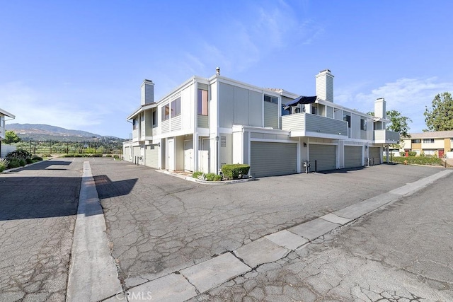 27066 Hidaway Ave Unit 6, Canyon Country, CA 91351 - view of asphalt road featuring a mountain view and community garages