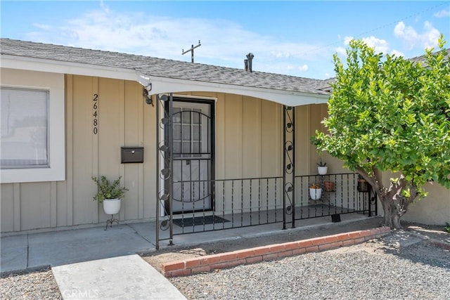 26480 Ridgemoor Rd, Menifee, CA 92586 - property entrance featuring a shingled roof, board and batten siding, and covered porch