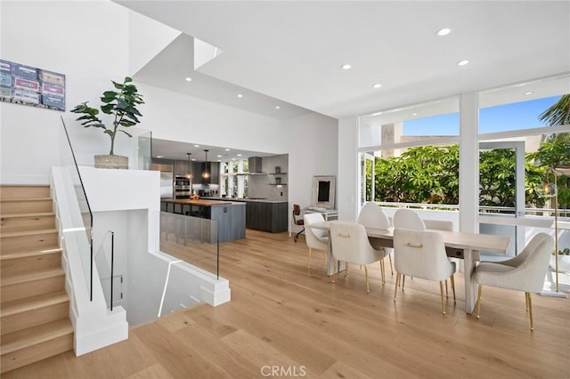 1061 Skyline Dr, Laguna Beach, CA 92651 - dining area featuring recessed lighting, light wood-type flooring, a wall of windows, and stairs