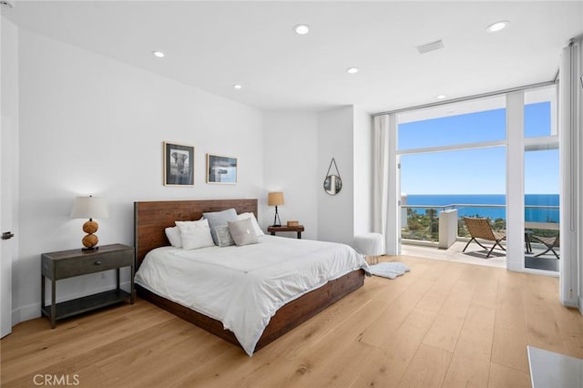 1061 Skyline Dr, Laguna Beach, CA 92651 - bedroom with floor to ceiling windows, light wood-type flooring, recessed lighting, access to exterior, and a water view