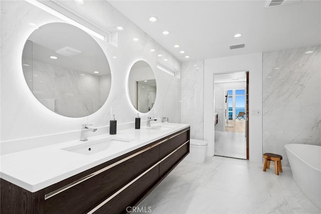 1061 Skyline Dr, Laguna Beach, CA 92651 - bathroom with marble tiled floors, double vanity, a freestanding tub, and recessed lighting