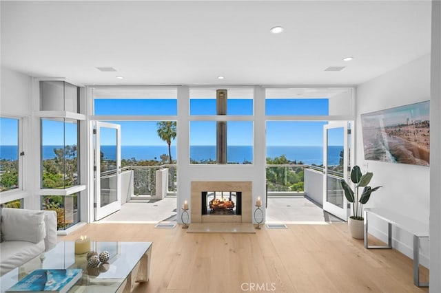 1061 Skyline Dr, Laguna Beach, CA 92651 - living room with a wall of windows, wood finished floors, a water view, a multi sided fireplace, and recessed lighting