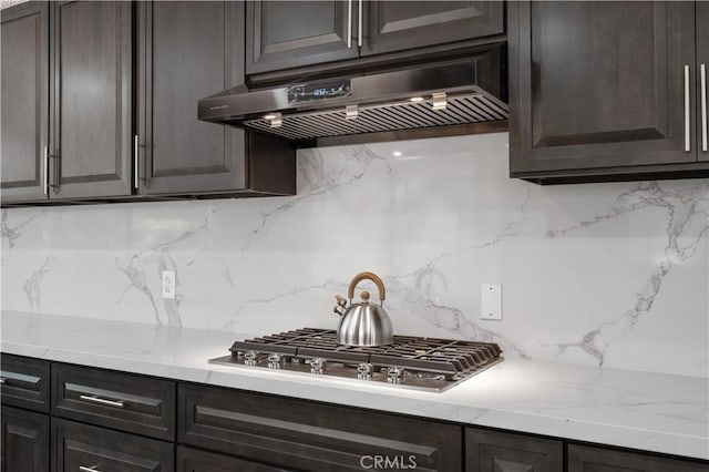 18561 Bert Rd, Riverside, CA 92508 - kitchen featuring under cabinet range hood, stainless steel gas cooktop, tasteful backsplash, and dark brown cabinetry