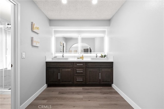 18561 Bert Rd, Riverside, CA 92508 - bathroom with double vanity, recessed lighting, wood finished floors, and a textured ceiling