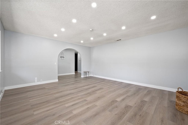18561 Bert Rd, Riverside, CA 92508 - spare room with arched walkways, a textured ceiling, recessed lighting, and light wood finished floors