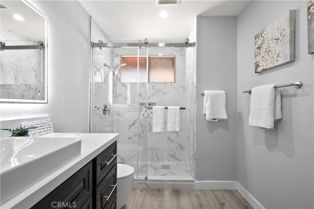 18561 Bert Rd, Riverside, CA 92508 - bathroom featuring vanity, a marble finish shower, wood finished floors, and recessed lighting