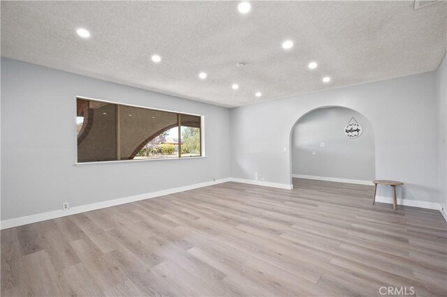 18561 Bert Rd, Riverside, CA 92508 - empty room with recessed lighting, arched walkways, wood finished floors, and a textured ceiling
