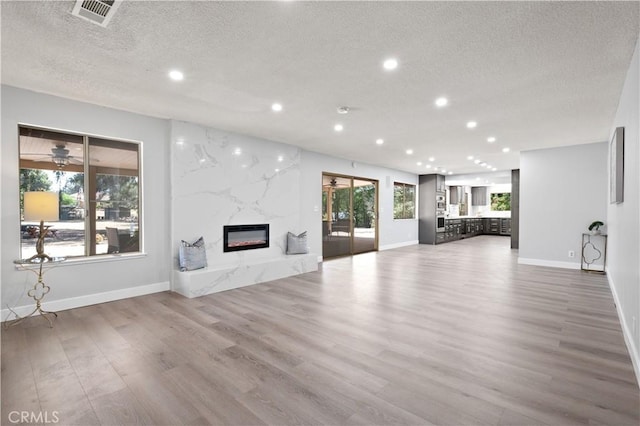 18561 Bert Rd, Riverside, CA 92508 - unfurnished living room featuring a textured ceiling, a fireplace, recessed lighting, and wood finished floors