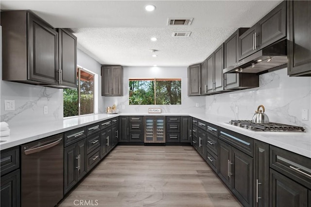 18561 Bert Rd, Riverside, CA 92508 - kitchen with appliances with stainless steel finishes, wine cooler, under cabinet range hood, a textured ceiling, and light countertops