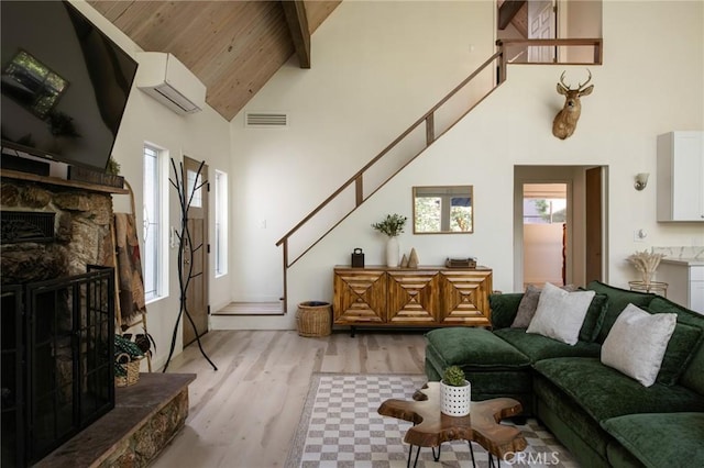 27984 St Bernard Ln, Lake Arrowhead, CA 92352 - living room with a wall unit AC, high vaulted ceiling, stairway, a fireplace, and light wood-style floors