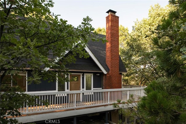 27984 St Bernard Ln, Lake Arrowhead, CA 92352 - rear view of property featuring a chimney, a wooden deck, and roof with shingles
