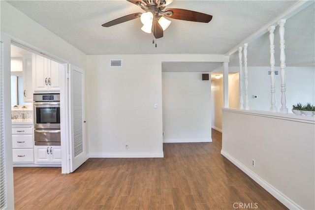 12682 Saint Mark St, Garden Grove, CA 92845 - kitchen featuring stainless steel oven, a warming drawer, white cabinets, ceiling fan, and wood finished floors