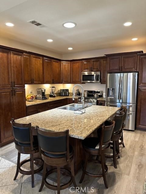28262 Cider, Menifee, CA 92585 - kitchen featuring stainless steel appliances, a kitchen bar, recessed lighting, light stone countertops, and a kitchen island with sink