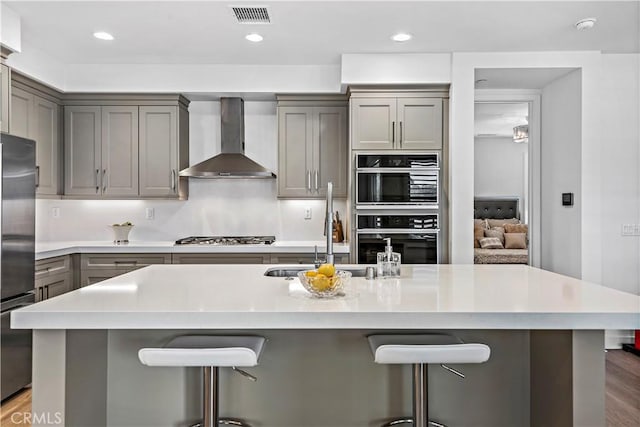 1309 Doheny Way, Dana Point, CA 92629 - kitchen featuring wall chimney exhaust hood, stainless steel appliances, gray cabinets, light countertops, and a breakfast bar area