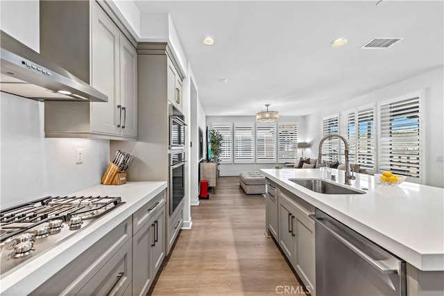1309 Doheny Way, Dana Point, CA 92629 - kitchen featuring wall chimney range hood, stainless steel appliances, gray cabinets, light countertops, and plenty of natural light