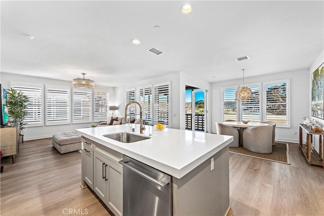 1309 Doheny Way, Dana Point, CA 92629 - kitchen with dishwasher, light wood finished floors, light countertops, pendant lighting, and an island with sink