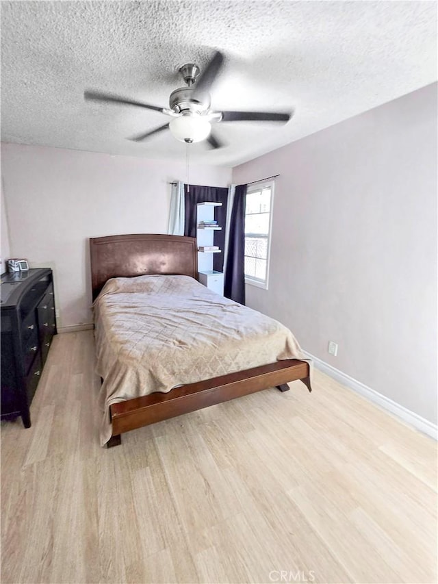 9313 Dearborn Ave, South Gate, CA 90280 - bedroom featuring light wood finished floors, a textured ceiling, and a ceiling fan