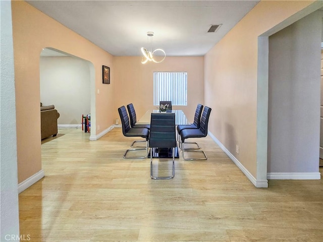 9313 Dearborn Ave, South Gate, CA 90280 - dining room featuring arched walkways, wood finished floors, and a chandelier