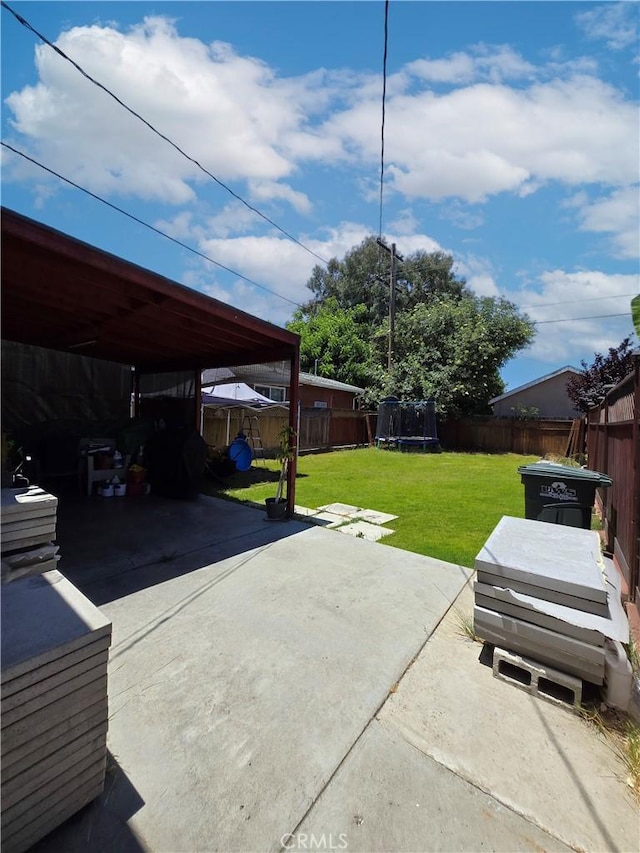 9313 Dearborn Ave, South Gate, CA 90280 - fenced backyard with a trampoline, a carport, a patio area, and driveway
