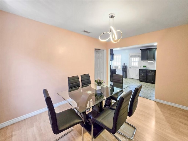 9313 Dearborn Ave, South Gate, CA 90280 - dining area with a chandelier and light wood-style flooring