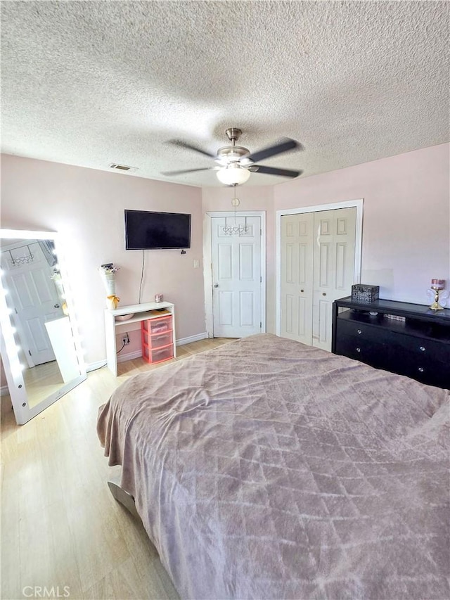 9313 Dearborn Ave, South Gate, CA 90280 - bedroom featuring wood finished floors, a ceiling fan, two closets, and a textured ceiling