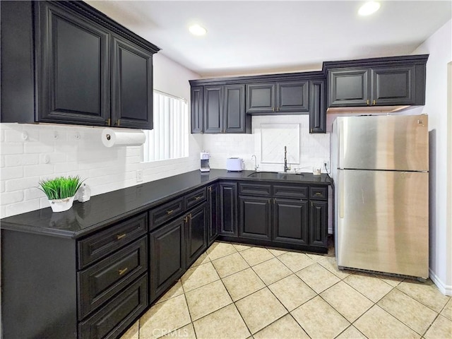 9313 Dearborn Ave, South Gate, CA 90280 - kitchen with freestanding refrigerator, decorative backsplash, light tile patterned floors, recessed lighting, and dark cabinets