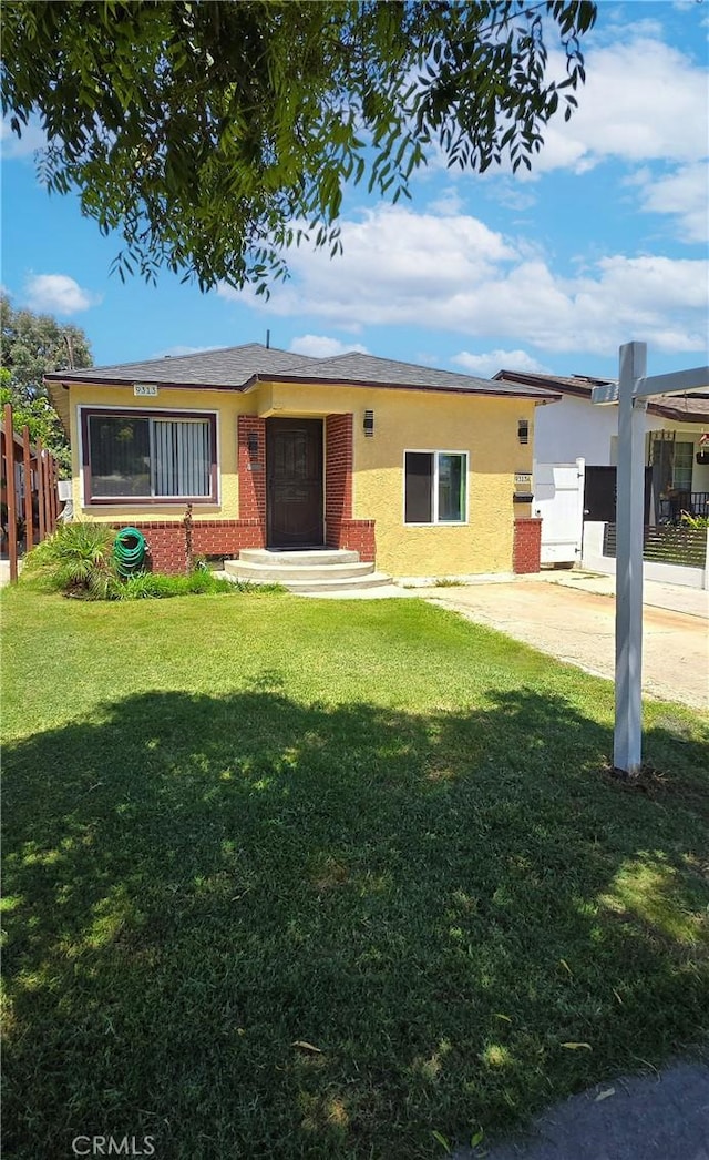 9313 Dearborn Ave, South Gate, CA 90280 - view of front facade with brick siding, a front lawn, and stucco siding