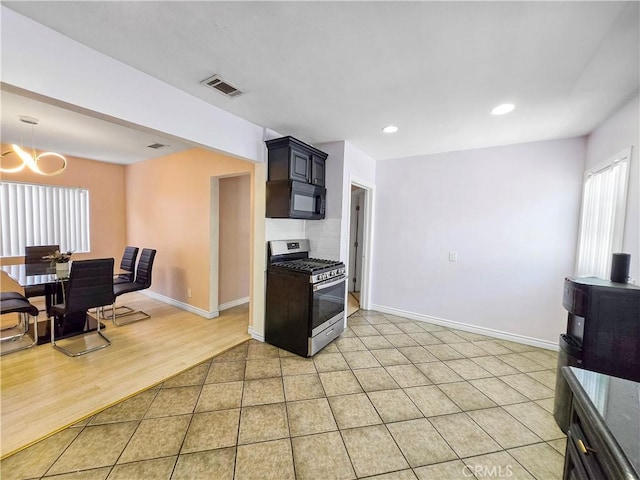 9313 Dearborn Ave, South Gate, CA 90280 - kitchen featuring stainless steel range with gas stovetop, black microwave, a chandelier, light tile patterned floors, and recessed lighting
