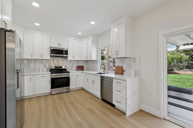 5471 Papagallo Dr, Oceanside, CA 92057 - kitchen with stainless steel appliances, healthy amount of natural light, light wood-style flooring, white cabinets, and recessed lighting