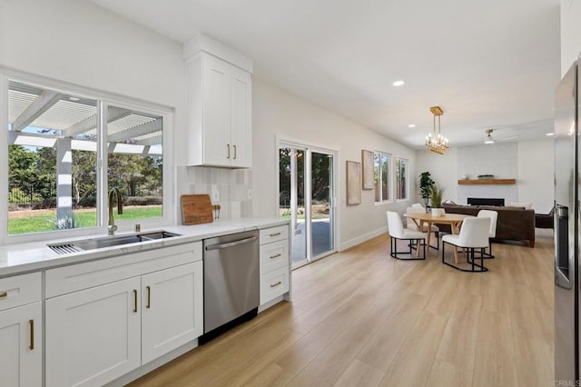 5471 Papagallo Dr, Oceanside, CA 92057 - kitchen featuring dishwasher, white cabinets, a fireplace, light countertops, and light wood-style floors