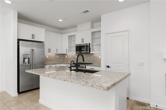 32813 Brunello Way, Temecula, CA 92591 - kitchen with stainless steel appliances, open shelves, light stone countertops, decorative backsplash, and white cabinets