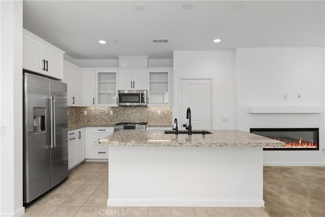 32813 Brunello Way, Temecula, CA 92591 - kitchen with appliances with stainless steel finishes, light stone countertops, white cabinetry, tasteful backsplash, and recessed lighting