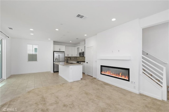 32813 Brunello Way, Temecula, CA 92591 - unfurnished living room with a glass covered fireplace, recessed lighting, light tile patterned floors, and light colored carpet
